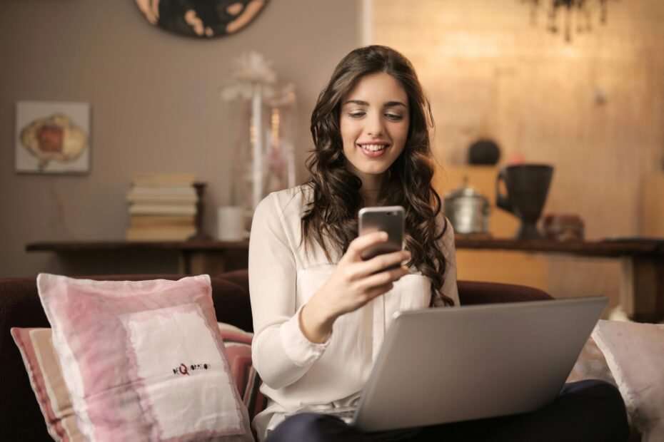 Woman browsing on her smartphone while sitting at a desk.