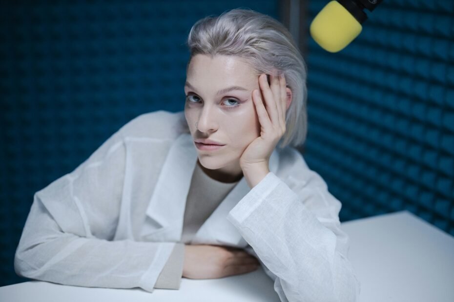 Woman resting her head on her hand in a podcast studio.