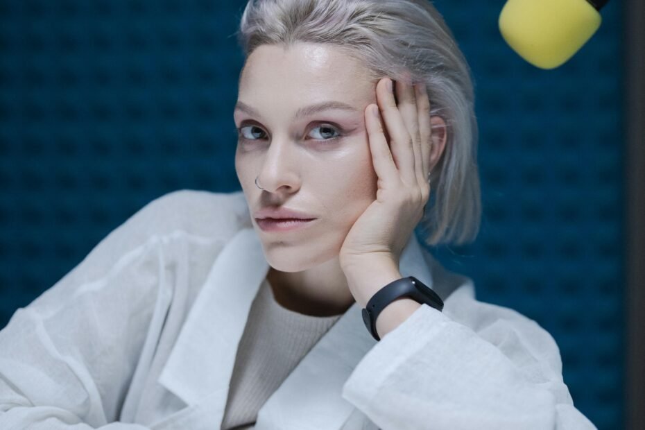 Woman in a contemplative pose during a podcast recording.