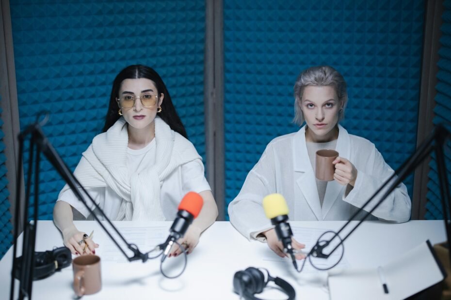 two women recording a podcast with microphones