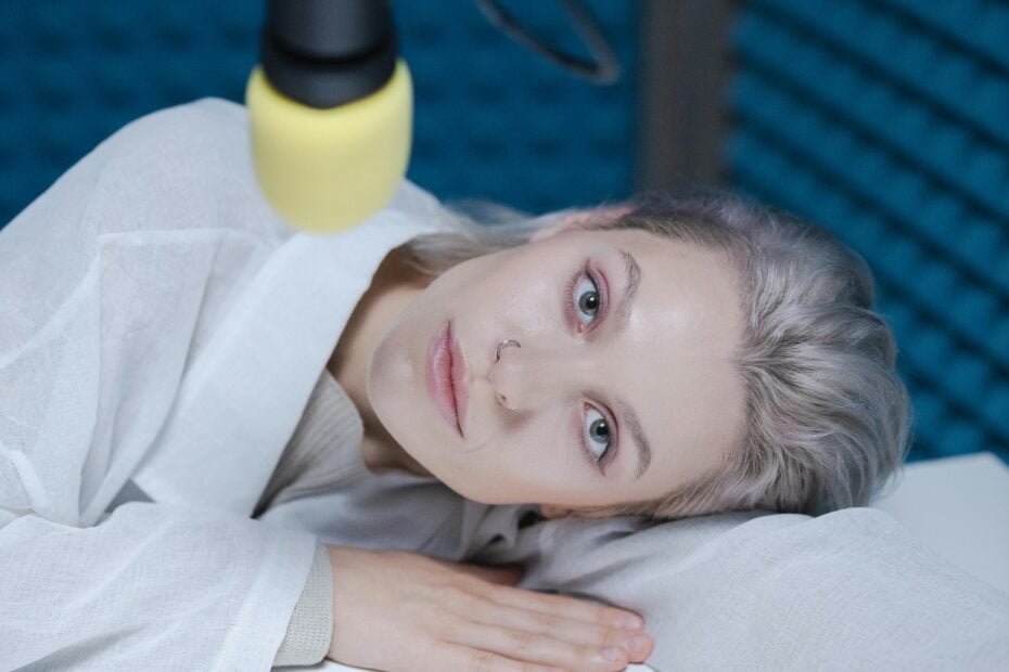 woman resting her head on a table during a podcast recording