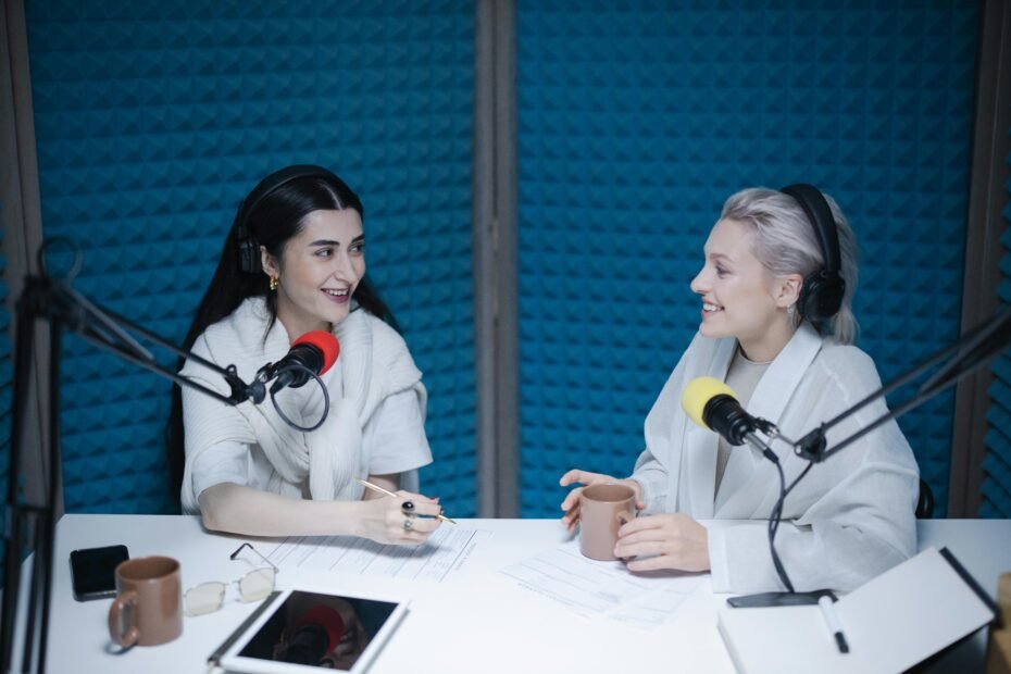 two women co-hosting a podcast with microphones