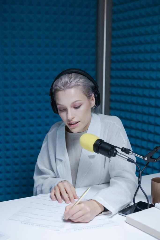 woman recording a podcast with a yellow microphone