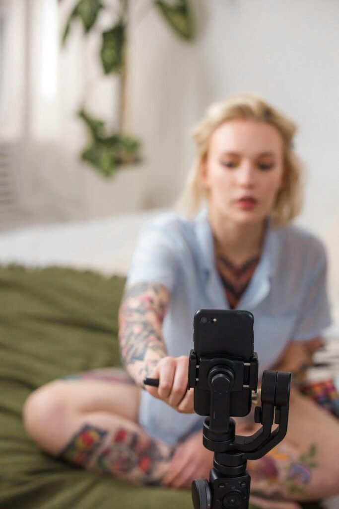 woman recording content with a smartphone mounted on a tripod