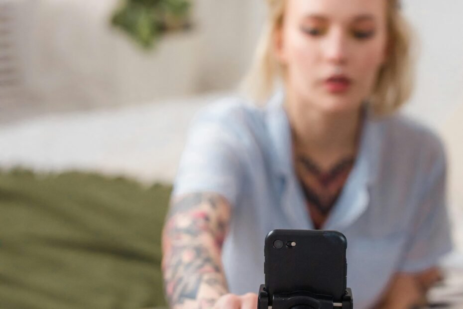 woman recording content with a smartphone mounted on a tripod