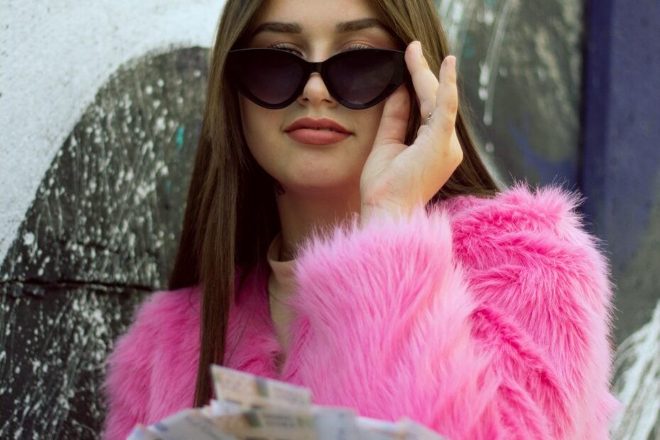 woman wearing sunglasses and holding a stack of money